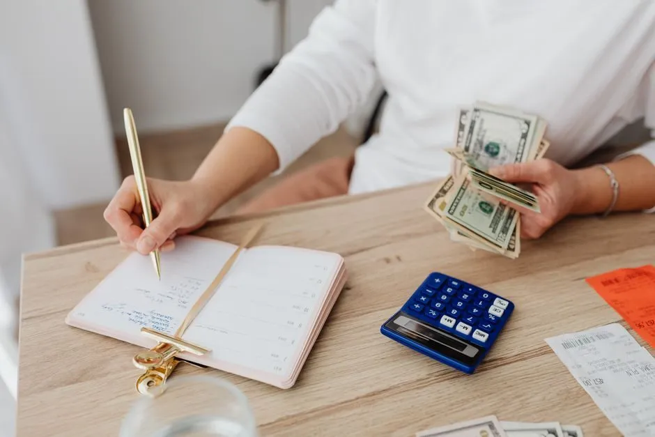Tiền mặt đặt cạnh sổ tay ghi chép các khoản chi